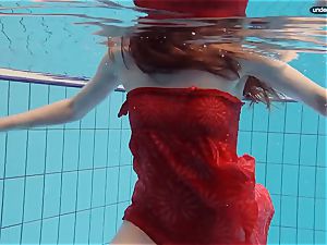 red dressed teen swimming with her eyes opened
